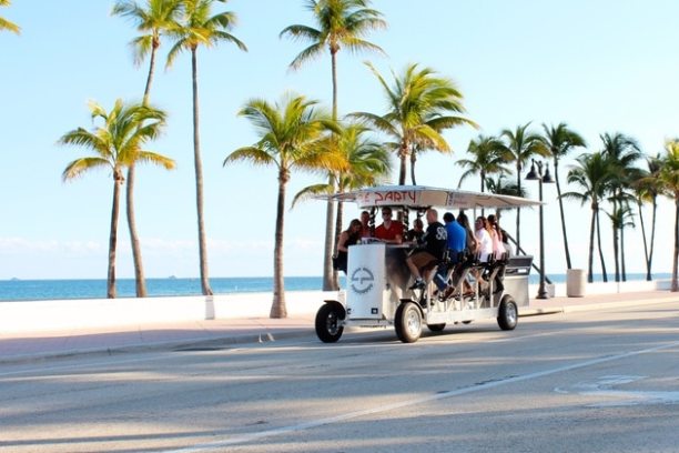 a person riding a skateboard down a street next to a palm tree
