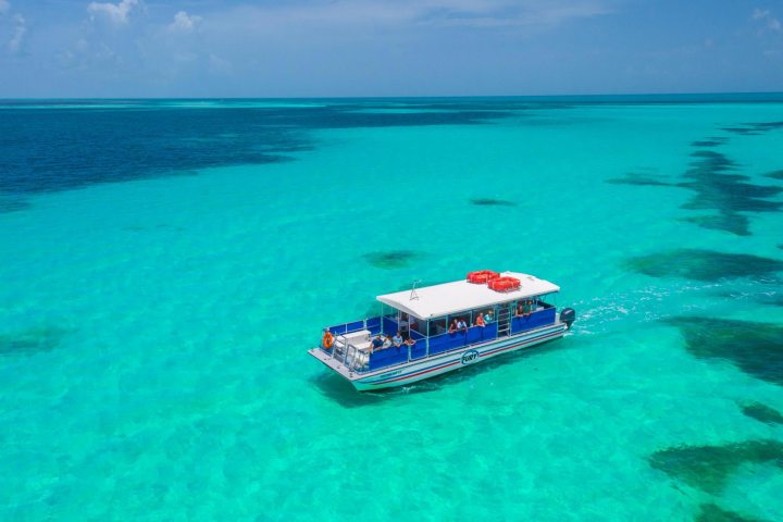 a blue and white boat sitting next to a body of water