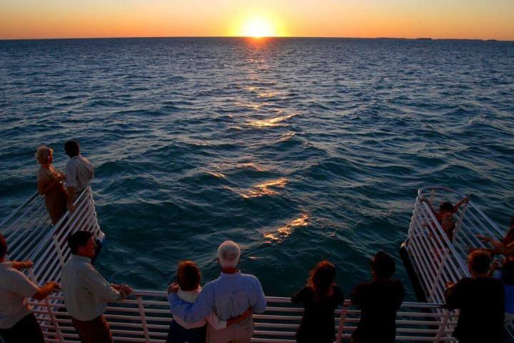a group of people standing next to a body of water