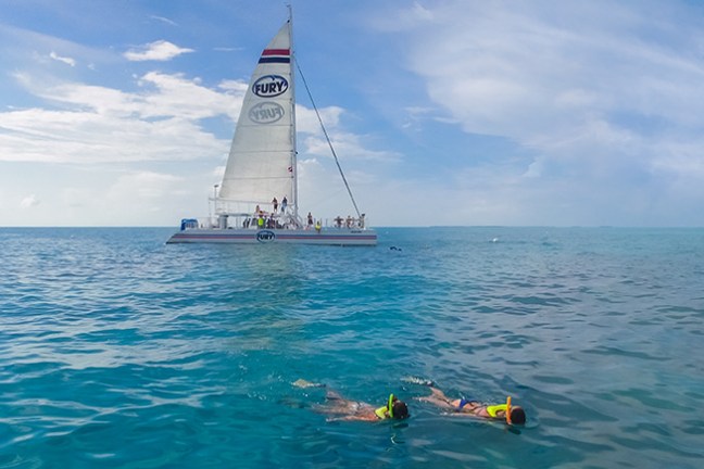 a man riding on the back of a boat in a body of water