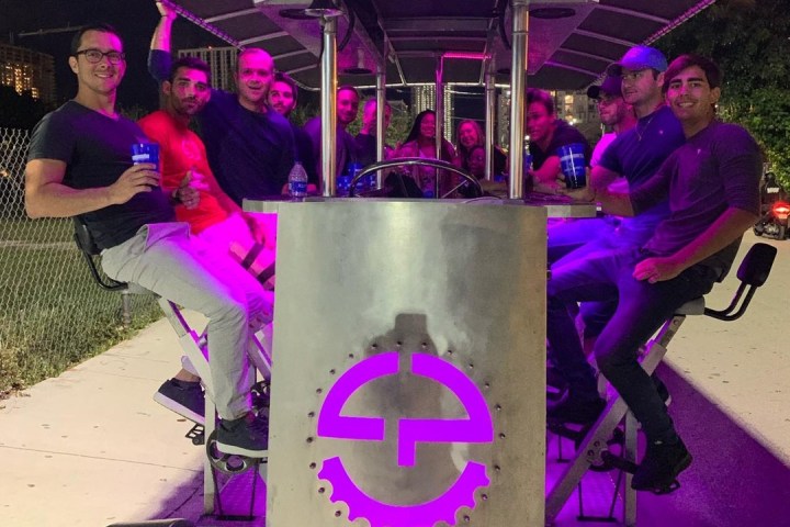 a person sitting on a stage with a purple umbrella